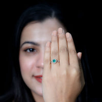 Emerald engagement ring with diamond halo from Rosec Jewels featuring a nature-inspired design and intricate metalwork.