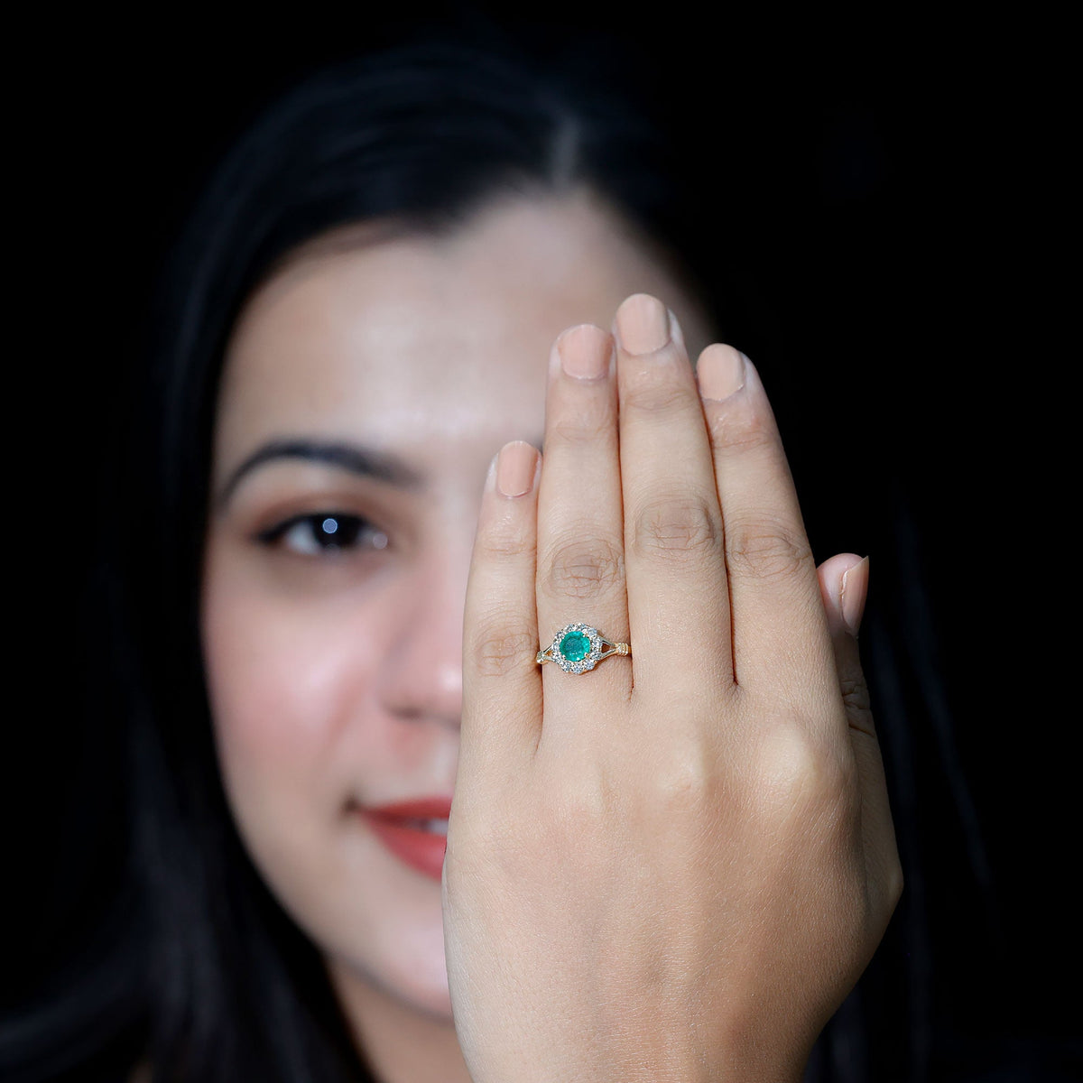 Emerald and diamond halo engagement ring by Rosec Jewels featuring a nature-inspired design and intricate metalwork.