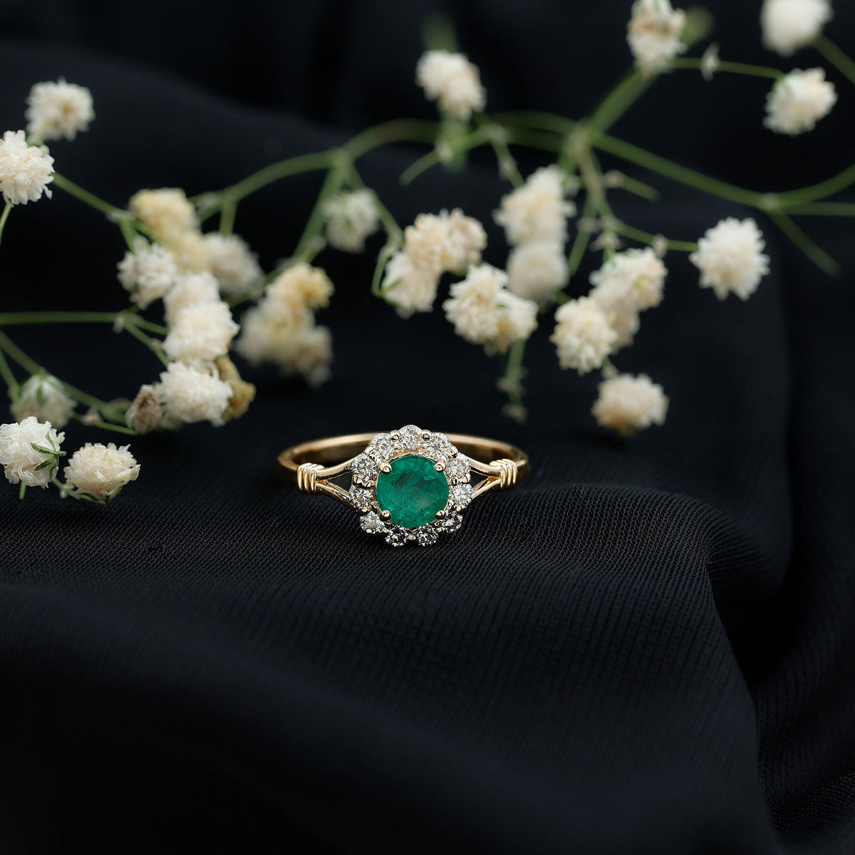Emerald engagement ring with diamond halo from Rosec Jewels featuring a nature-inspired design and intricate metalwork.