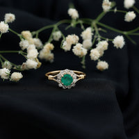 Emerald engagement ring with diamond halo from Rosec Jewels featuring a nature-inspired design and intricate metalwork.