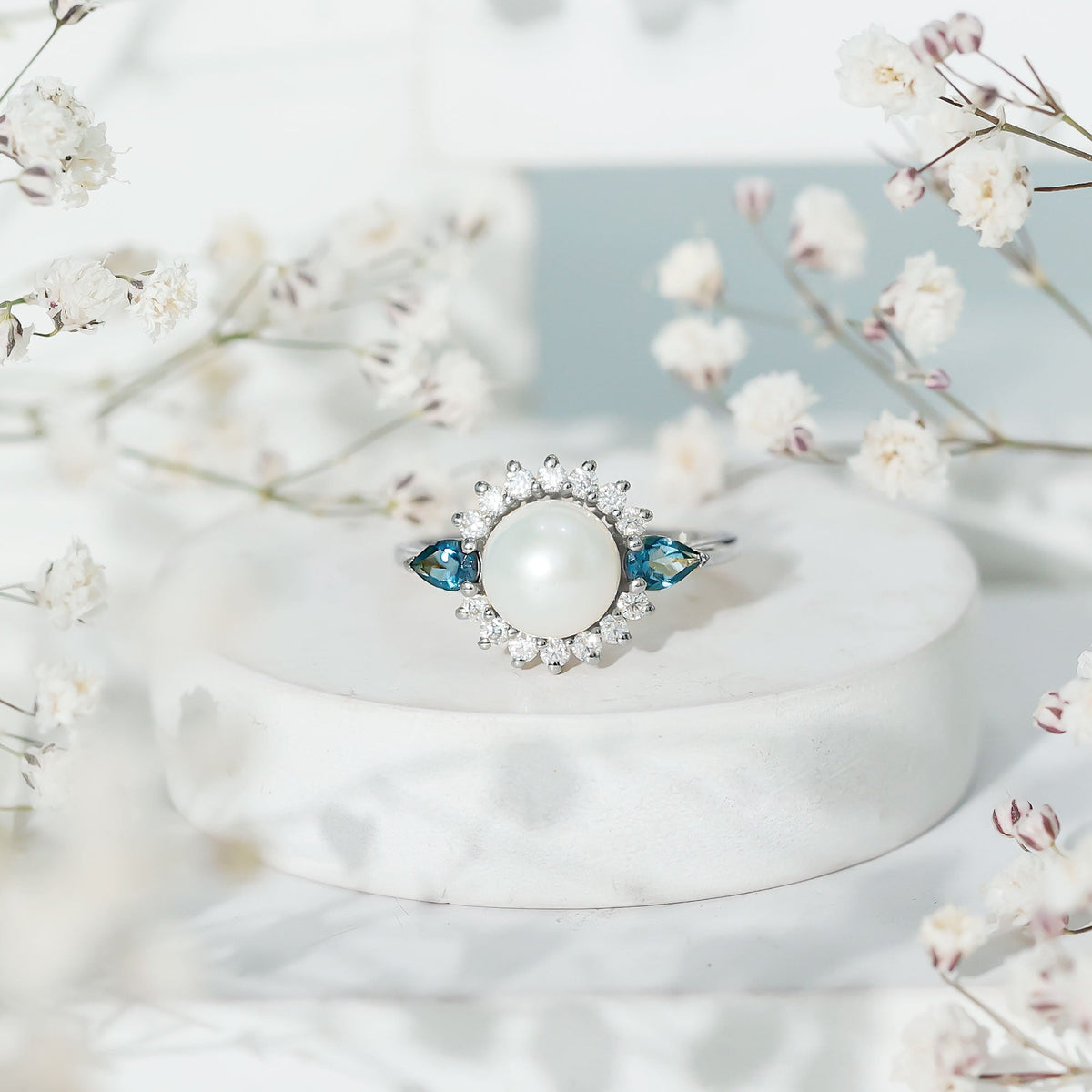 Rosec Jewels 8mm freshwater cultured pearl engagement ring with blue topaz, showcasing a delicate design and sparkling gemstones.