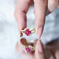 Real ruby flower engagement ring with diamond split shank featuring a vibrant ruby centerpiece and sparkling diamonds in a gold setting.
