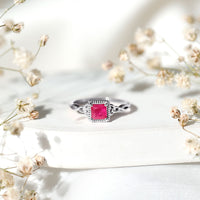Natural 0.8 carat princess cut ruby promise ring with Celtic knot design, crafted by Rosec Jewels, shown on a white background.