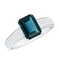 Rosec Jewels 6x8mm London Blue Topaz side stone engagement ring with diamond accent, featuring an emerald cut gemstone design.