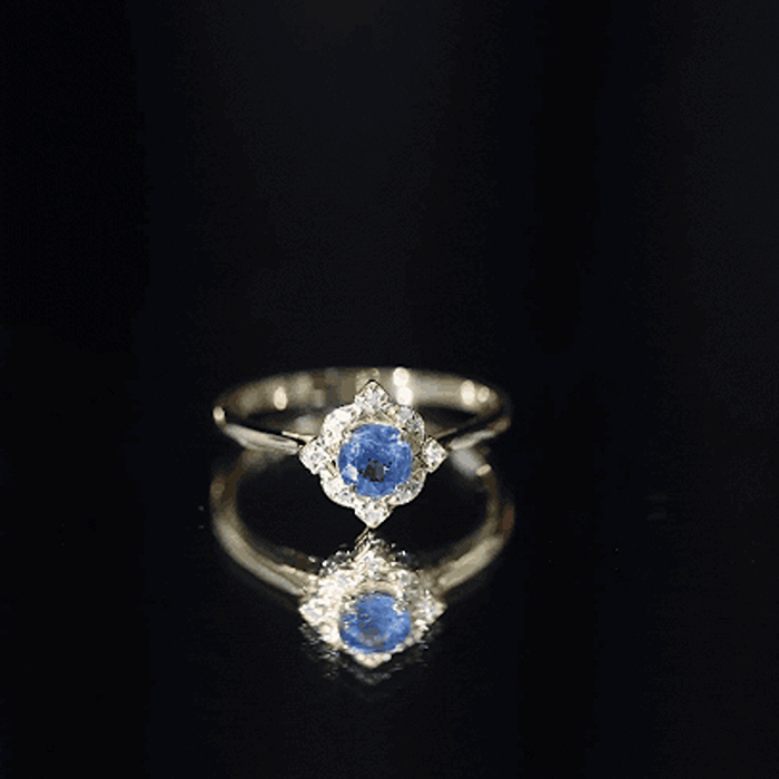 Vintage style 0.9 carat blue sapphire engagement ring with diamond halo, featuring intricate yellow gold band and detailed design.