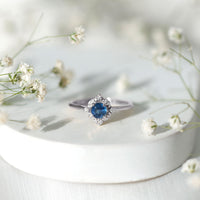 Vintage style 0.9 carat blue sapphire engagement ring with diamond halo by Rosec Jewels, featuring intricate metalwork and sparkling stones.