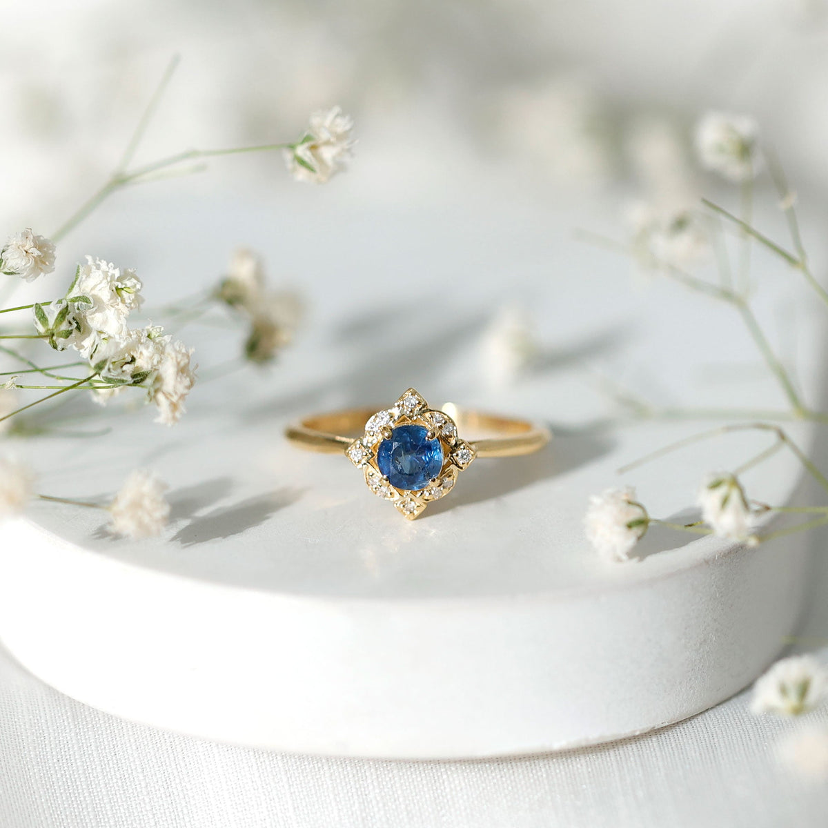 Vintage style 0.9 carat blue sapphire engagement ring with diamond halo, featuring intricate band details, by Rosec Jewels.