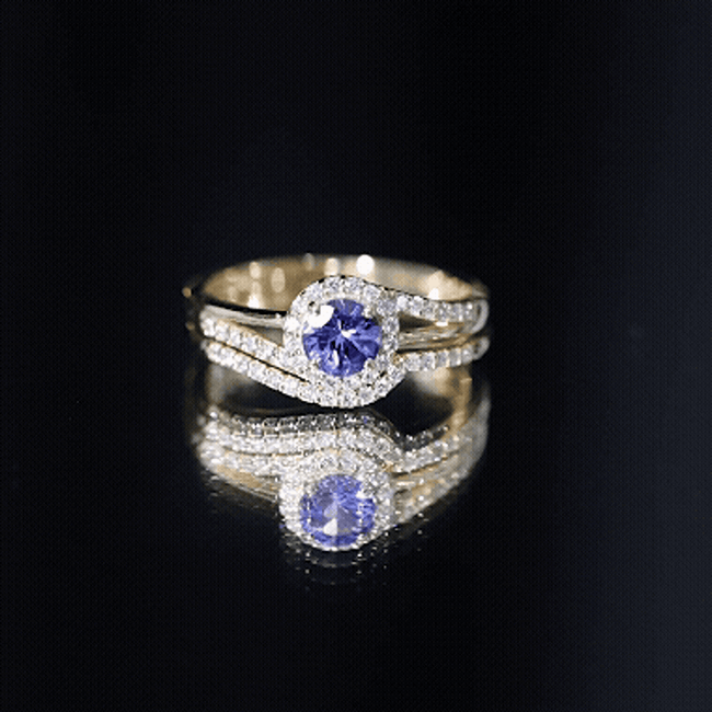Genuine Tanzanite engagement ring with diamond enhancer, featuring a vibrant blue Tanzanite gemstone in a detailed silver setting.