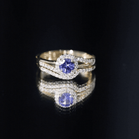 Genuine Tanzanite engagement ring with diamond enhancer, featuring a vibrant blue Tanzanite gemstone in a detailed silver setting.