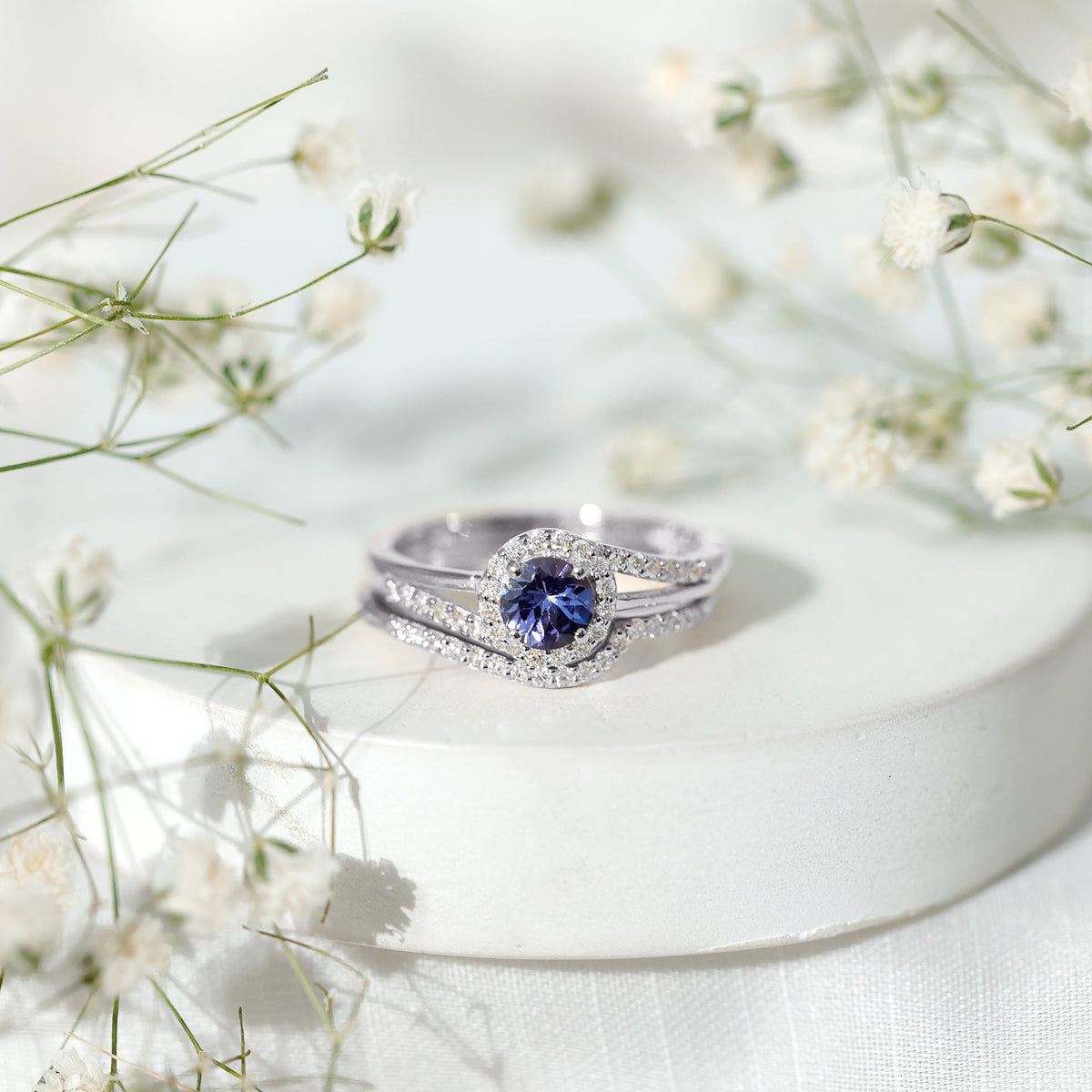 Genuine Tanzanite engagement ring with diamond enhancer featuring a deep blue tanzanite gemstone and sparkling diamond accents.
