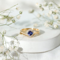 Genuine Tanzanite engagement ring with diamond enhancer featuring a deep blue tanzanite gemstone and sparkling diamond accents.