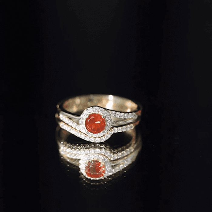 Yellow fire opal engagement ring with diamond enhancer, featuring intricate band details and sparkling gemstones.