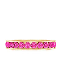Round lab-created pink sapphire half eternity ring in channel setting, featuring a sleek band with sparkling pink sapphires.