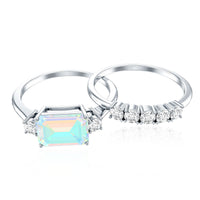 Ethiopian Opal and diamond engagement ring with emerald cut, paired with a matching wedding band, by Rosec Jewels.