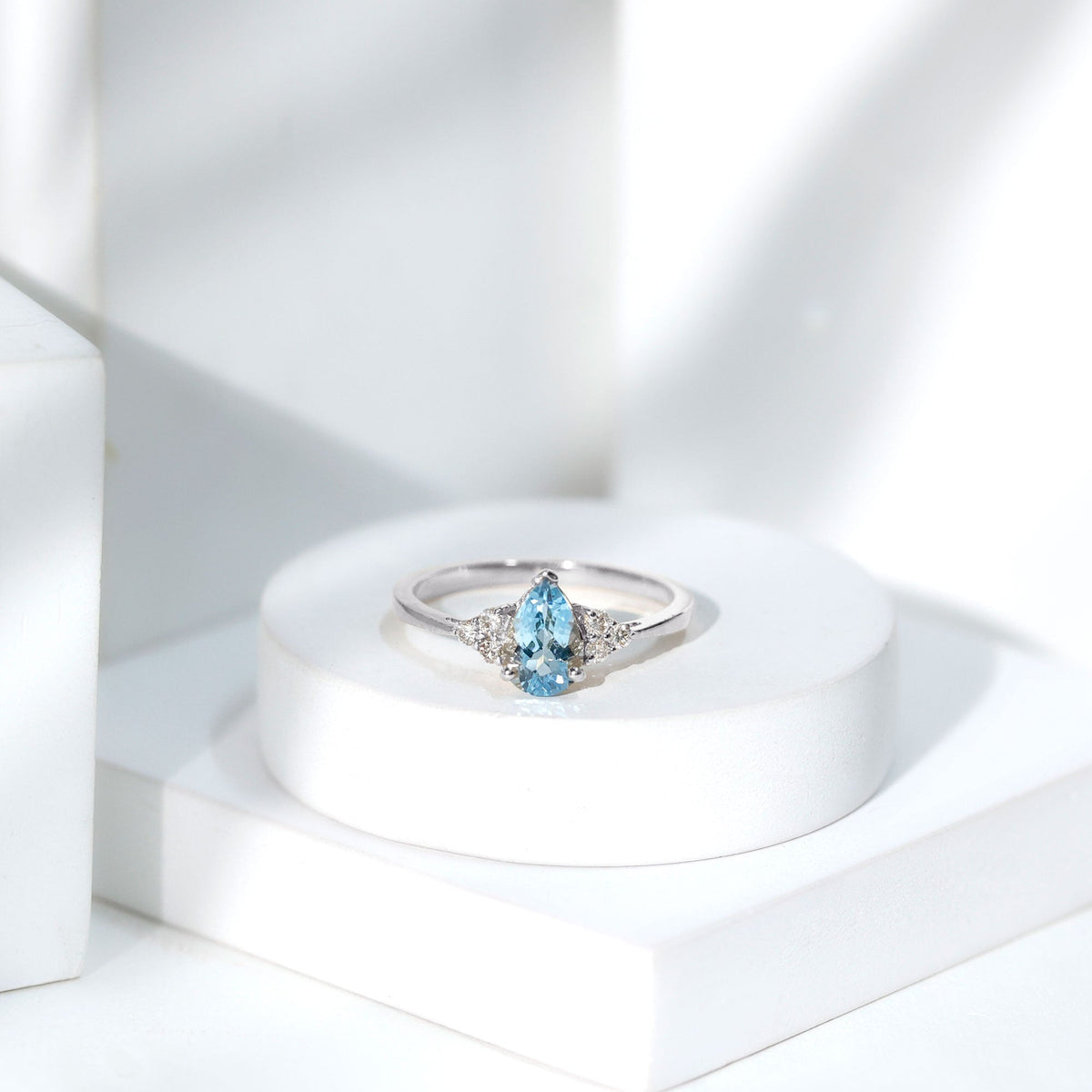 Elegant 1 Carat Aquamarine pear-shaped engagement ring with diamond trio accents from Rosec Jewels.