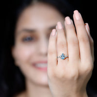 Elegant 1 Carat aquamarine pear-shaped engagement ring with diamond trio setting by Rosec Jewels, showcasing intricate design and sparkling stones.