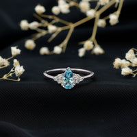 Rosec Jewels 1 Carat Aquamarine pear engagement ring with diamond trio, featuring a blue aquamarine and sparkling side stones.