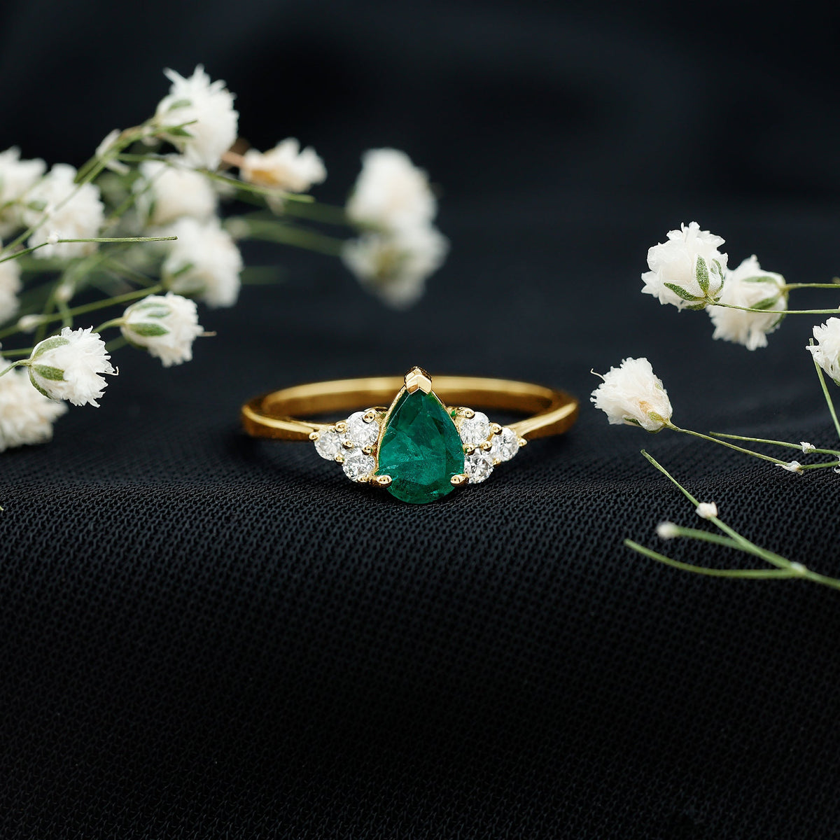 Pear-shaped emerald engagement ring with 0.6 carat AAA quality gemstone and diamond accents, featuring a rose gold band.