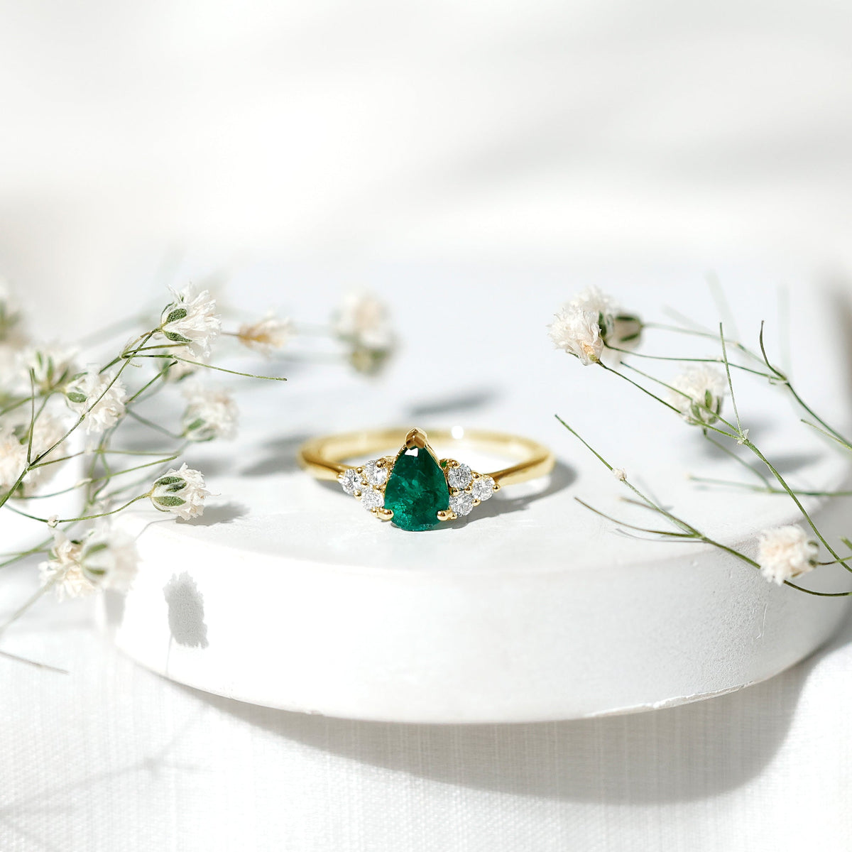 Pear-shaped emerald engagement ring with 0.6 carat AAA quality stone and diamond accents, crafted by Rosec Jewels.