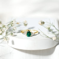 Pear-shaped emerald engagement ring with 0.6 carat AAA quality stone and diamond accents, crafted by Rosec Jewels.