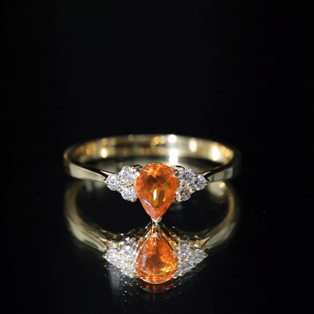 Pear-shaped 0.6 carat fire opal engagement ring with diamond trio by Rosec Jewels, showcasing vibrant orange gemstone and sparkling diamonds.
