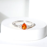 Pear-shaped 0.6 carat fire opal engagement ring with diamond trio accents from Rosec Jewels.