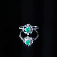 Vintage-style emerald and diamond oval engagement ring by Rosec Jewels featuring a stunning center stone and intricate band detail.