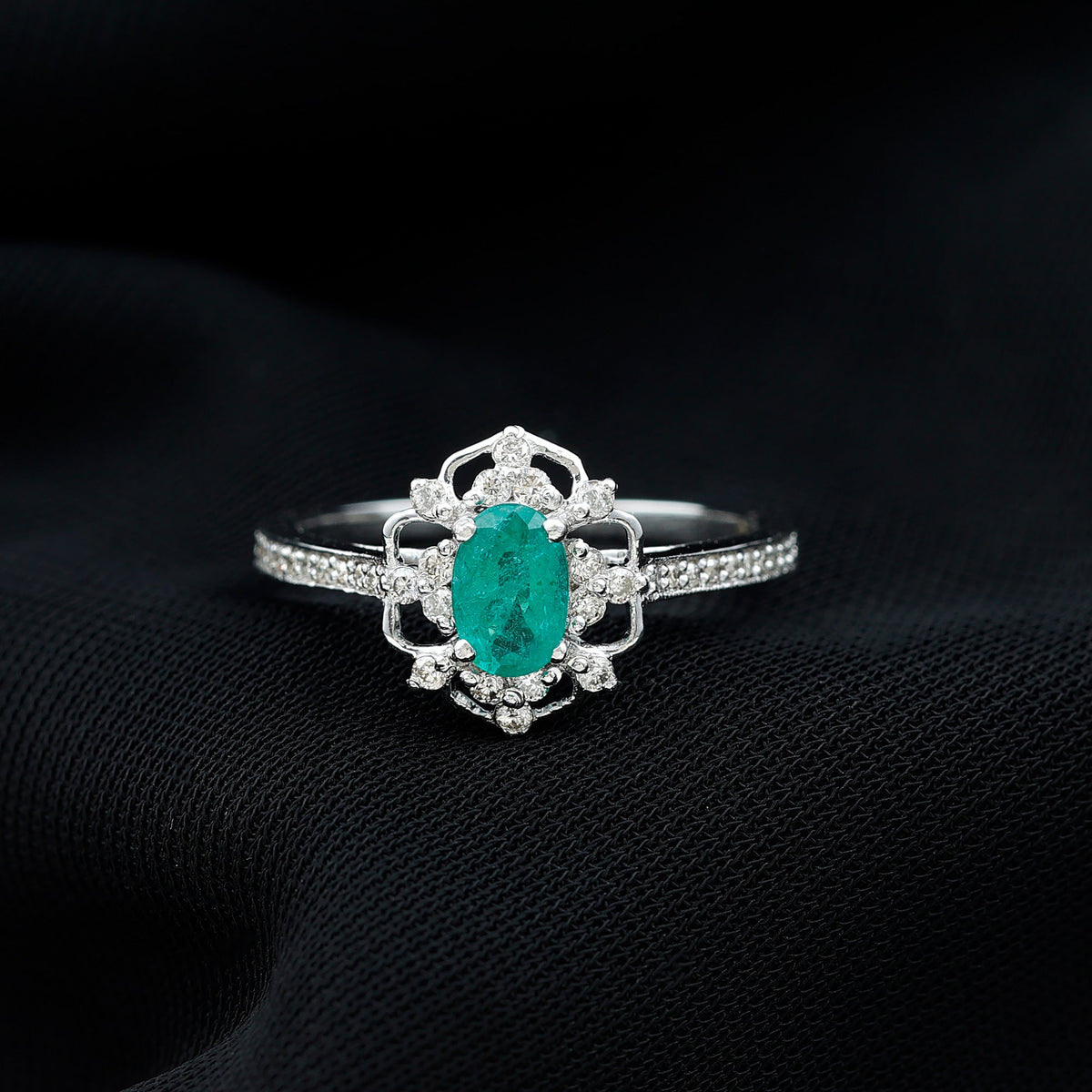 Vintage style emerald and diamond oval engagement ring from Rosec Jewels featuring a detailed gold band and intricate design.