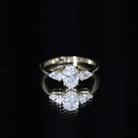 Oval and pear cut moissanite three stone engagement ring by Rosec Jewels featuring sparkling gemstones and elegant band design.