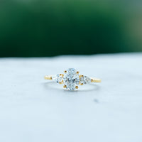 Oval and pear cut moissanite three-stone engagement ring by Rosec Jewels featuring sparkling gemstones and a sleek band design.