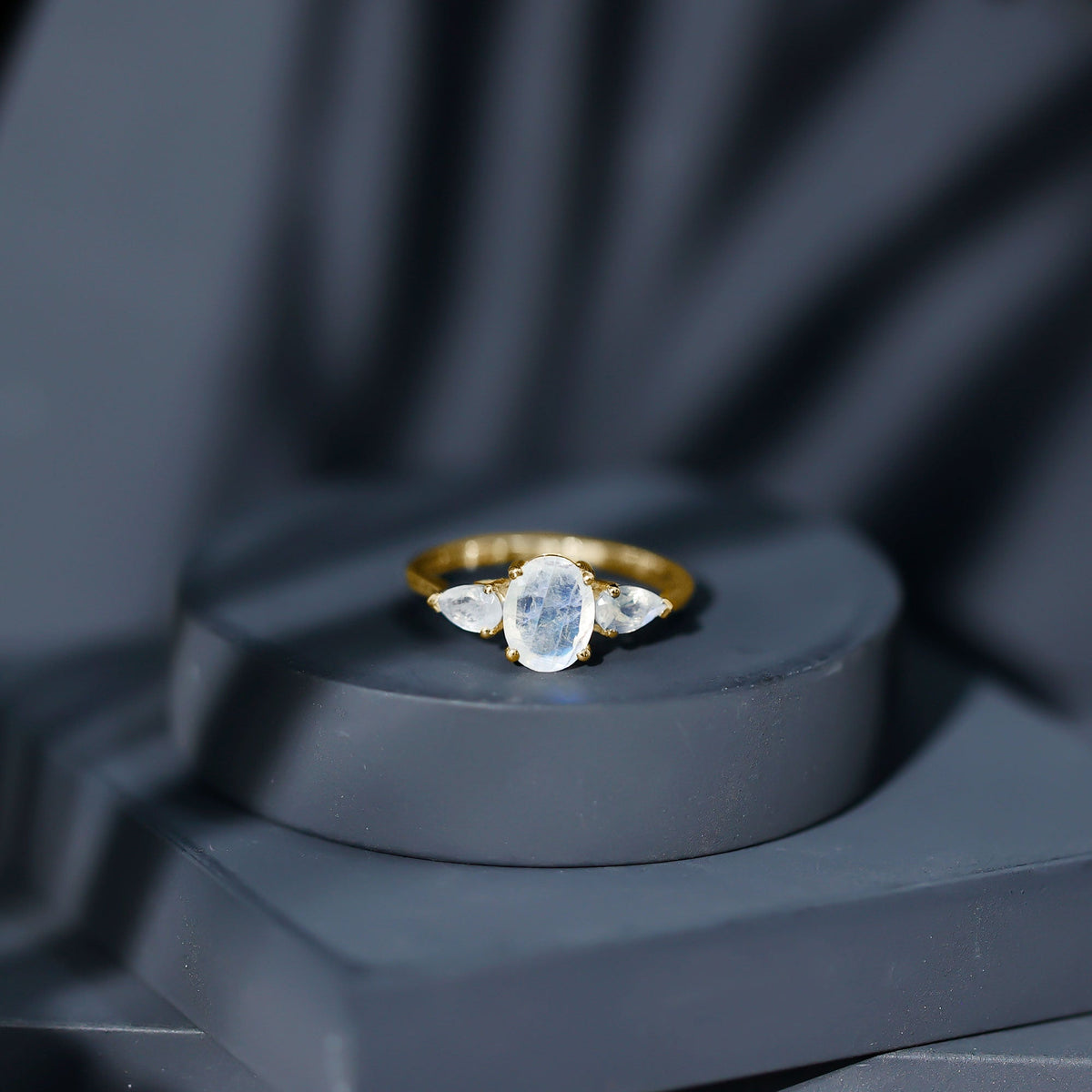 Natural moonstone three-stone engagement ring featuring rose gold band and sparkling gemstones, designed by Rosec Jewels.