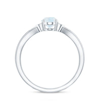 Oval cut moonstone solitaire ring with diamond accent, crafted by Rosec Jewels, featuring a elegant silver band.