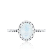 Oval moonstone engagement ring with diamond halo by Rosec Jewels, featuring a polished band and sparkling center stone.