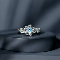 Natural aquamarine flower-inspired engagement ring with diamond accents, crafted by Rosec Jewels, showcasing intricate floral design.