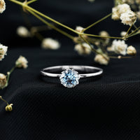 Round cut aquamarine solitaire engagement ring with 0.8 carat weight, set in a sleek ring band by Rosec Jewels.
