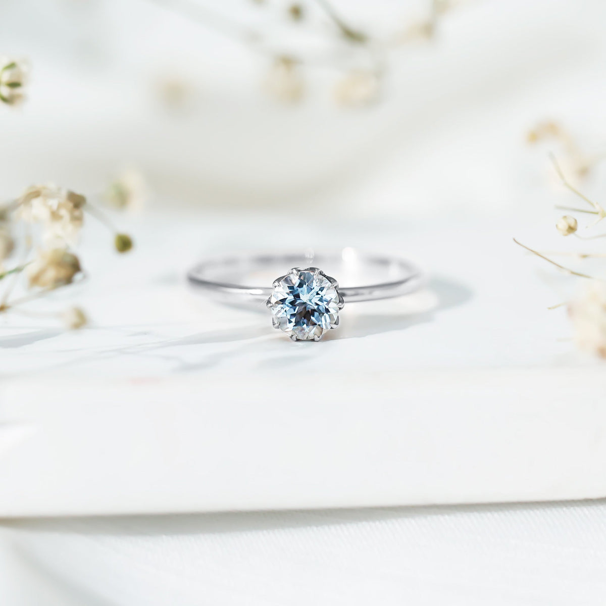Round cut aquamarine solitaire engagement ring with a 0.8 carat center stone, set in a sleek band by Rosec Jewels.
