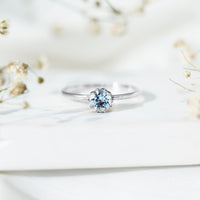 Round cut aquamarine solitaire engagement ring with a 0.8 carat center stone, set in a sleek band by Rosec Jewels.
