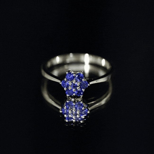 Certified round blue sapphire cluster flower ring showcasing a floral design with vibrant blue sapphires and a silver band.