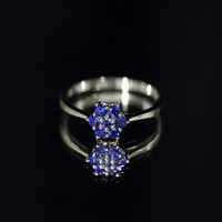 Certified round blue sapphire cluster flower ring showcasing a floral design with vibrant blue sapphires and a silver band.