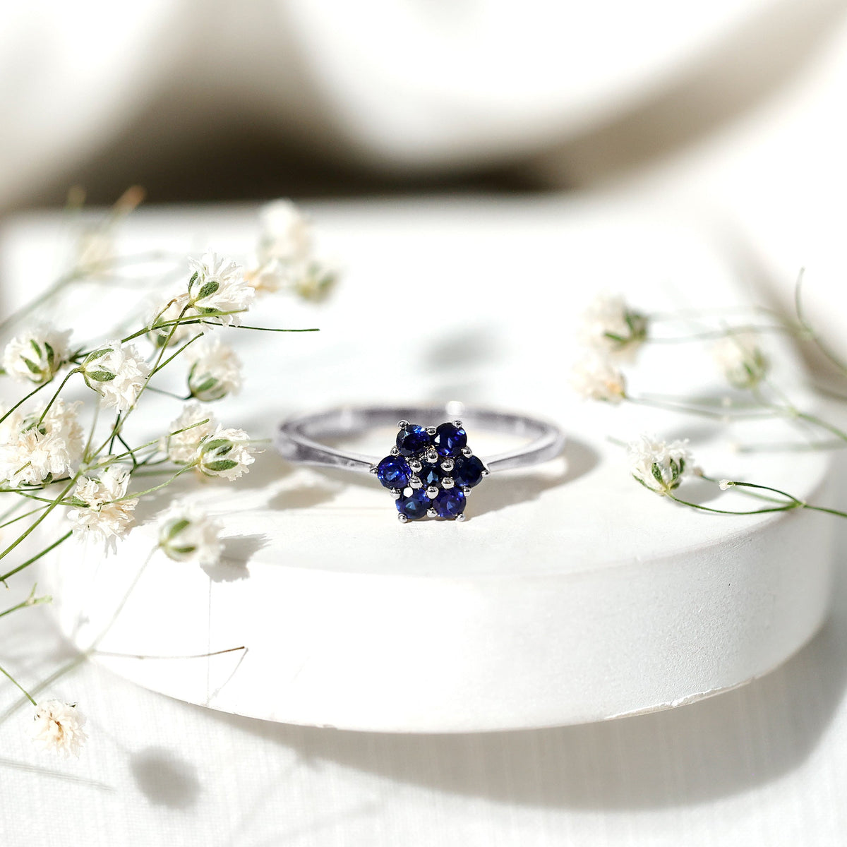 Blue sapphire cluster flower ring with round shape sapphires and silver band, crafted by Rosec Jewels.