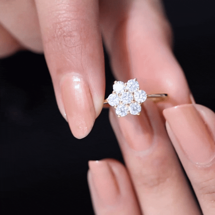 Round shape moissanite cluster flower engagement ring with yellow gold band, featuring sparkling floral design.