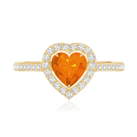 Heart-shaped fire opal engagement ring with diamond halo, 0.9 carats, featuring rose gold band and intricate detailing.