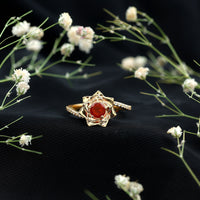 Flower-inspired fire opal engagement ring with diamond accents by Rosec Jewels, showcasing intricate floral design and sparkling gemstones.
