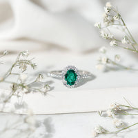Oval lab-grown emerald halo engagement ring with diamond accents from Rosec Jewels, showcasing the detailed gemstone setting.