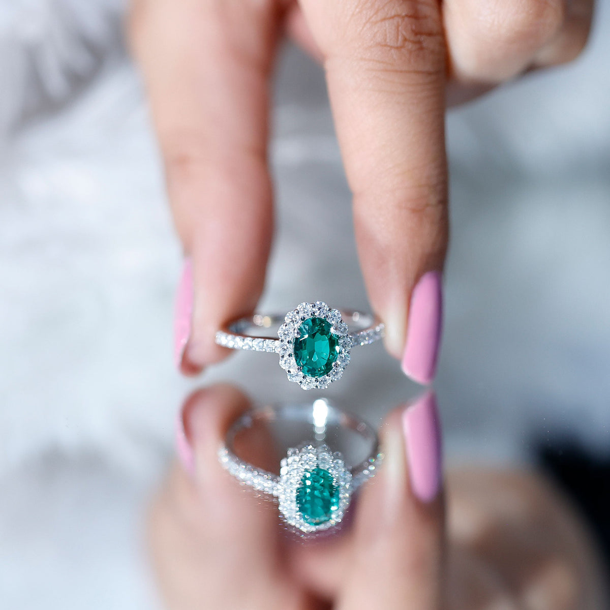 Oval lab-grown emerald halo engagement ring with diamond accents in a Rosec Jewels ring setting, showcasing intricate craftsmanship.