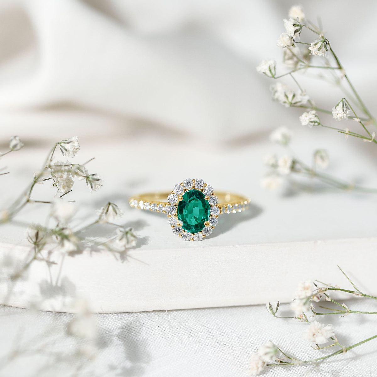 Oval lab-grown emerald halo engagement ring with 1.2 carats, set in a Rosec Jewels ring with sparkling side stones.