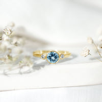 Bezel set real aquamarine and diamond engagement ring by Rosec Jewels featuring a central aquamarine gemstone with surrounding diamonds.
