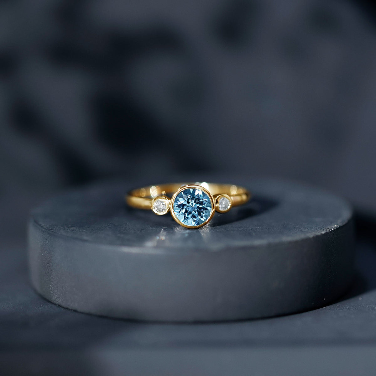 Bezel set real aquamarine diamond engagement ring by Rosec Jewels featuring a central aquamarine gemstone and sparkling diamonds.