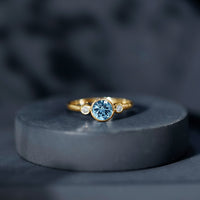 Bezel set real aquamarine diamond engagement ring by Rosec Jewels featuring a central aquamarine gemstone and sparkling diamonds.