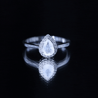 Pear-shaped moonstone halo engagement ring with diamond accents by Rosec Jewels, showcasing the ring's detailed design and sparkling stones.